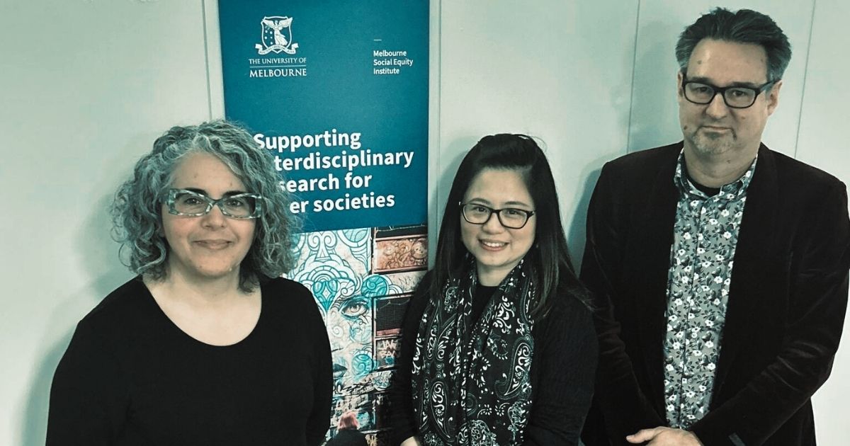 Three members of Seedkit team standing in front of vertical Melbourne Social Equity Institute banner