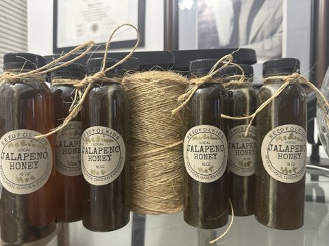 Bottles of SEEDFOLKids jalapeño honey tied with twine