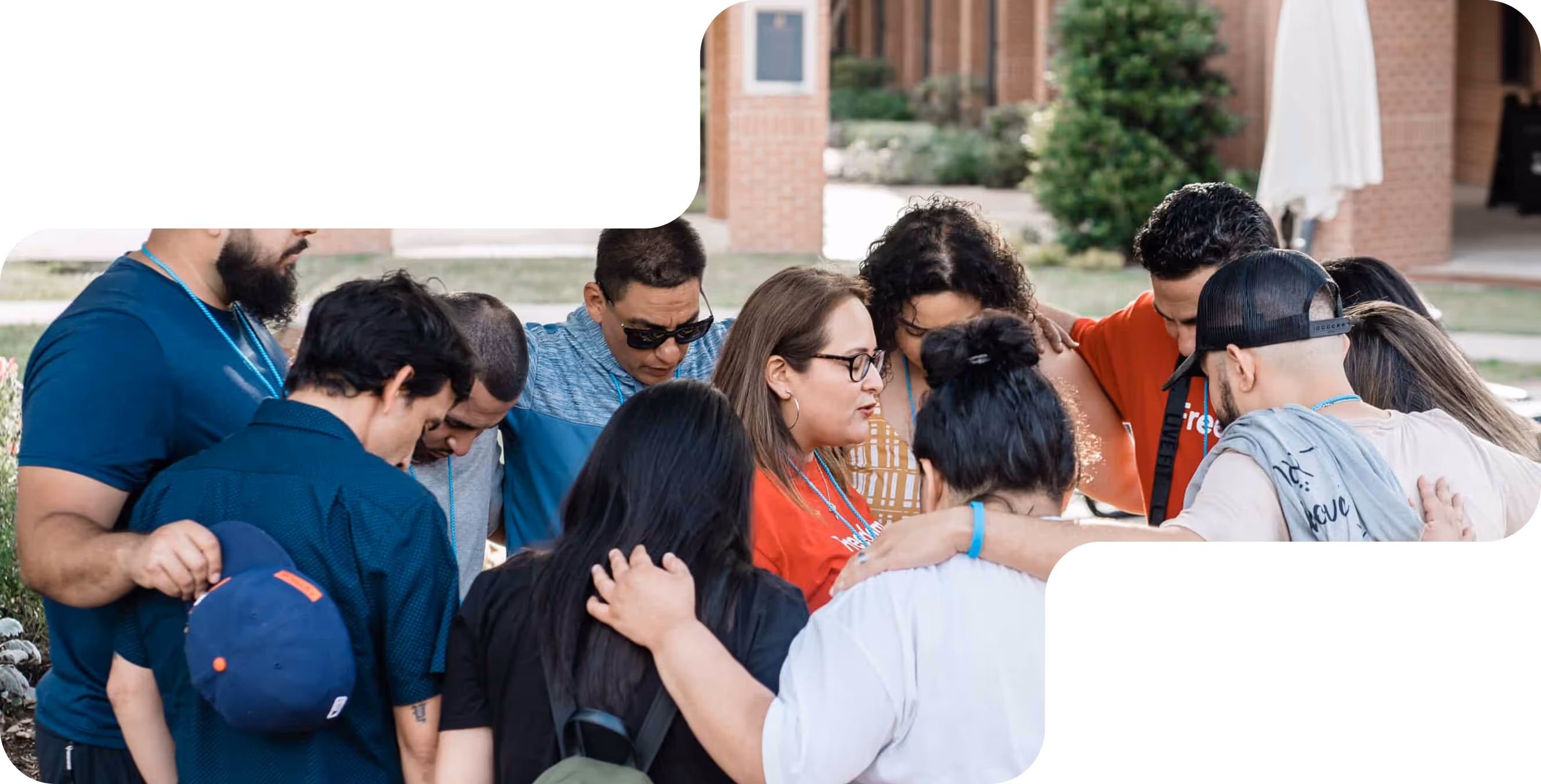 Group of diverse people standing close together in a huddle outdoors, showing support and unity.