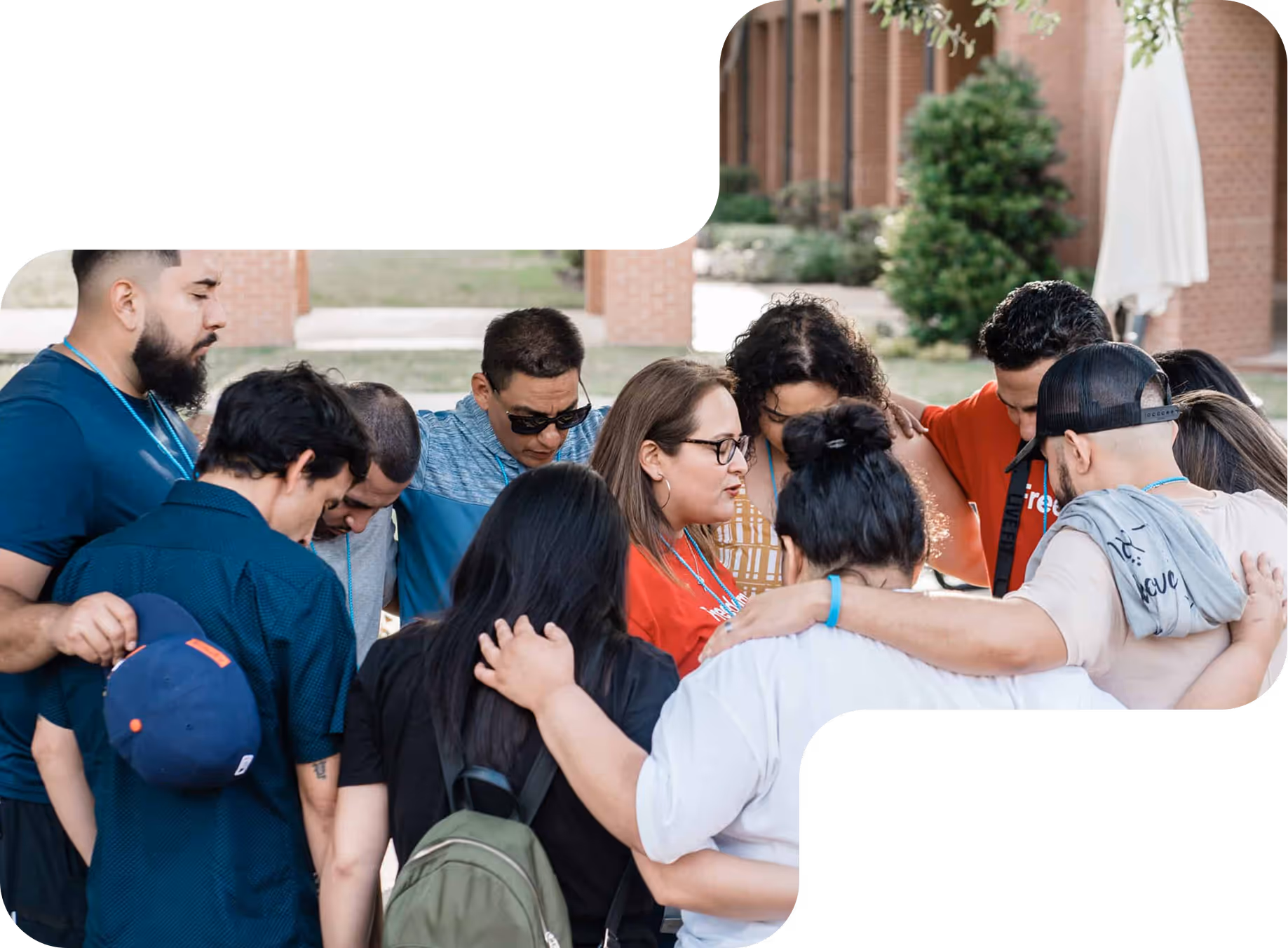 Group of diverse people standing close together in a huddle outdoors, showing support and unity.