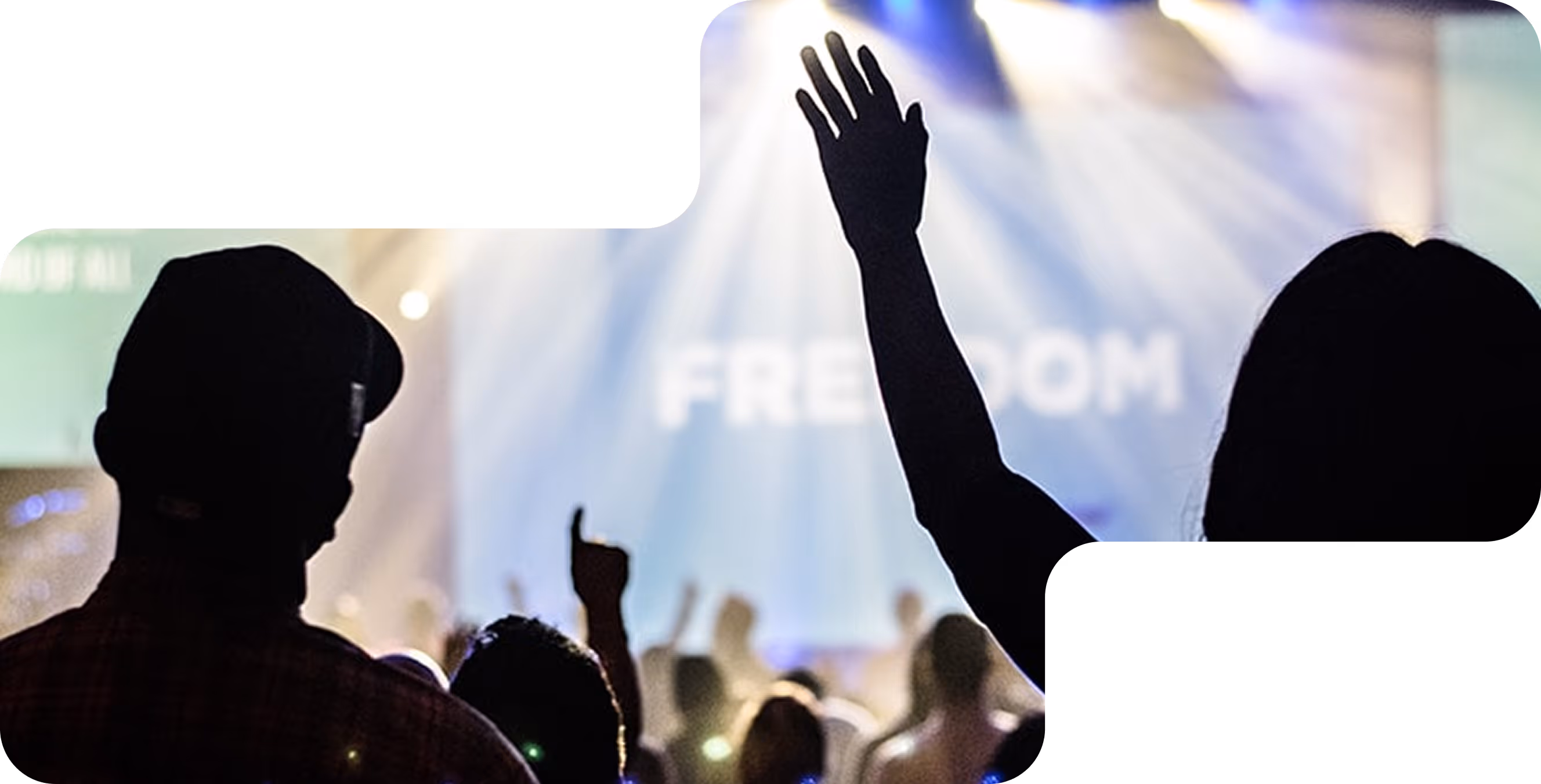 Silhouettes of raised hands in a crowd under bright stage lights with the word 'FREEDOM' visible in the background.