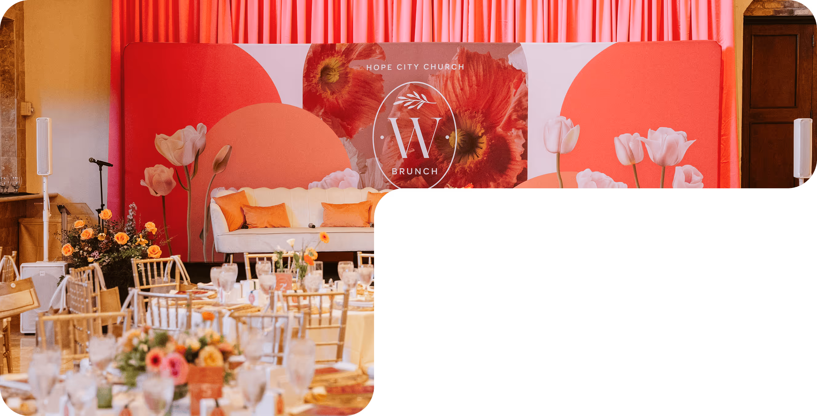 Event setup with gold chairs and round tables in front of a stage with white couch, orange pillows, floral arrangement, and a backdrop reading 'Hope City Church W Brunch'.