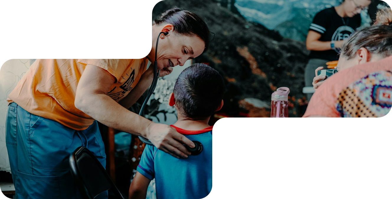 Healthcare worker uses a stethoscope to check a young boy's back in a community setting.