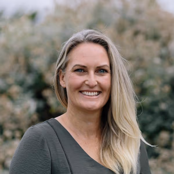 Headshot of Erin in a grey dress.