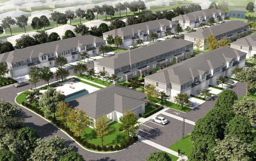 Aerial view of a residential complex with multiple rows of townhouses, green lawns, trees, parking spaces, and a community building.