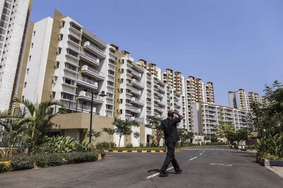 A pedestrian walks in front of residential apartment buildings in Palava City on the outskirts of... [+] Mumbai, India, on Thursday, May 25, 2017. (Photographer: Dhiraj Singh/Bloomberg)