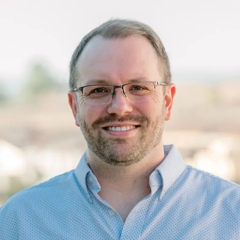 A man wearing glasses and a blue shirt.