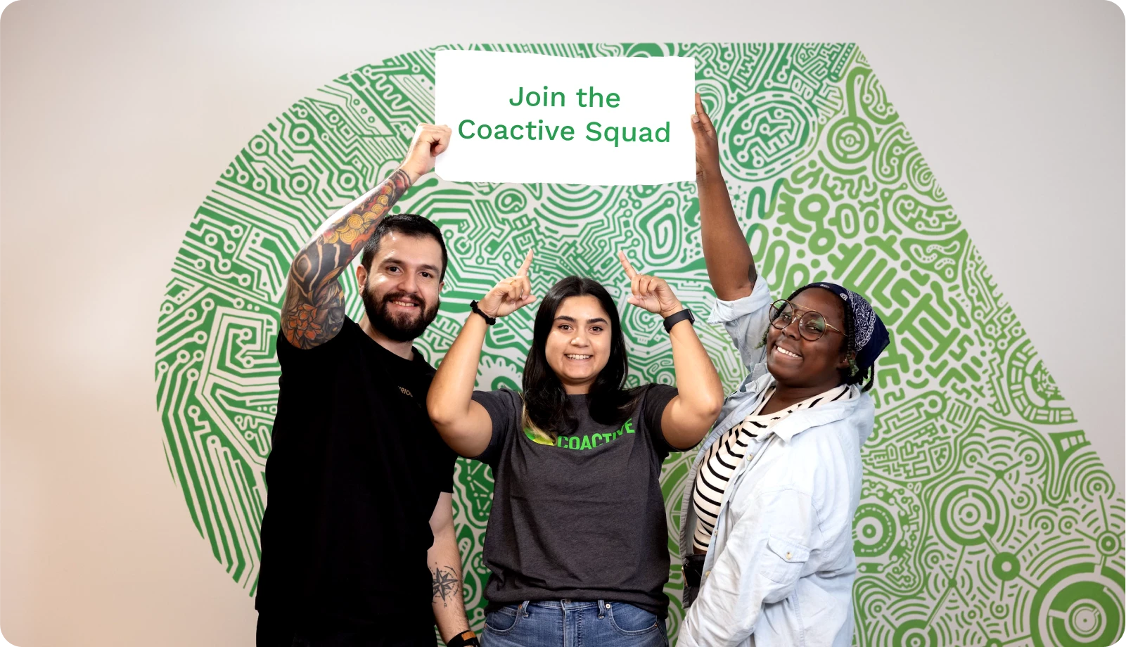 Three team members enthusiastically present a sign stating "Join the Creative Team," promoting teamwork and creativity.

