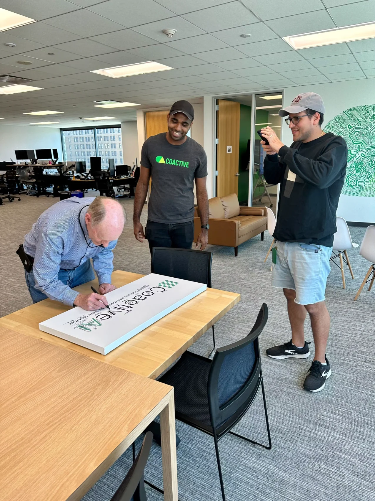 A team member signs the Coactive AI sign, a welcoming gesture and sign of officially joining the team!