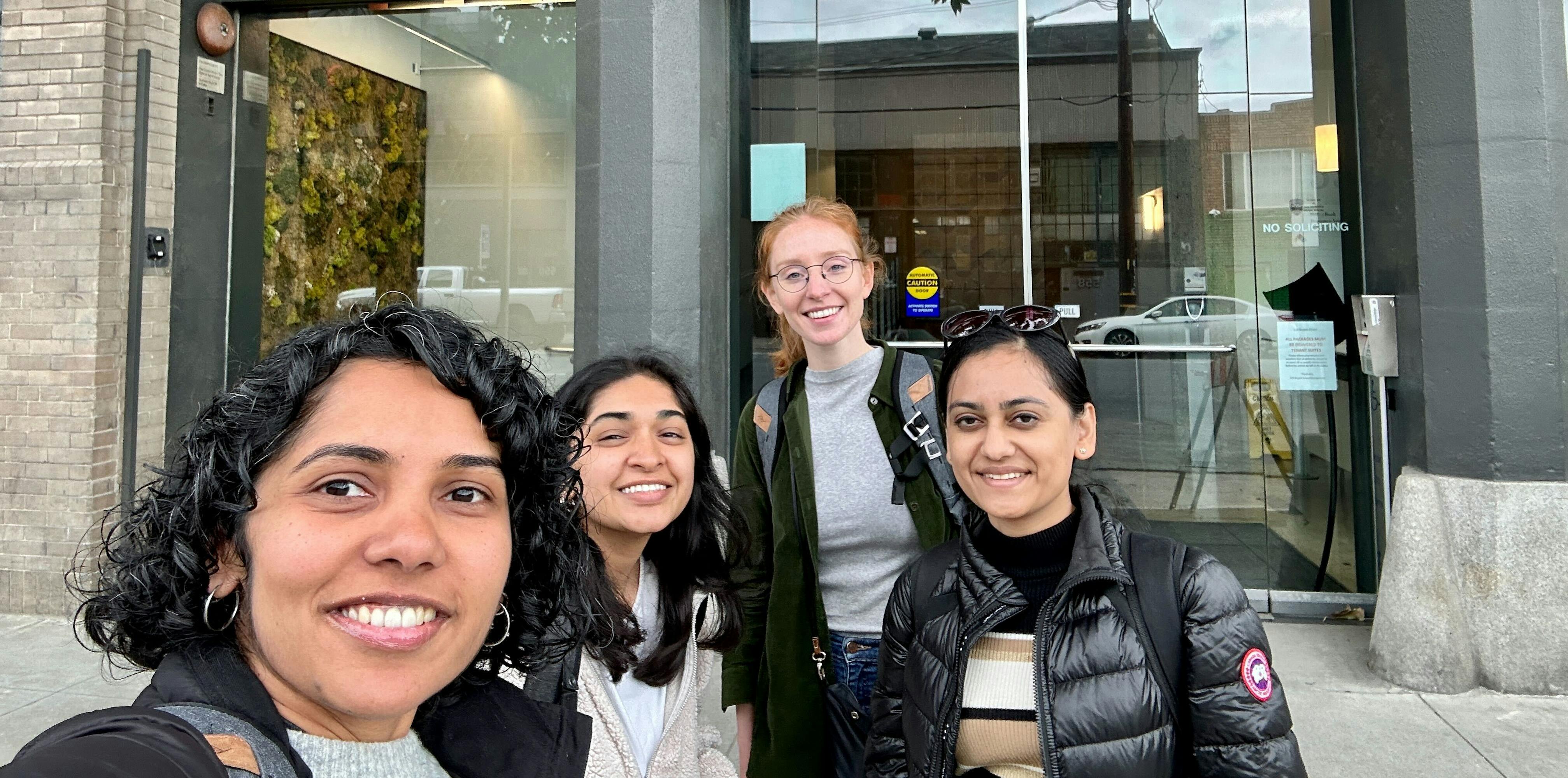 Smiling team members taking a group selfie