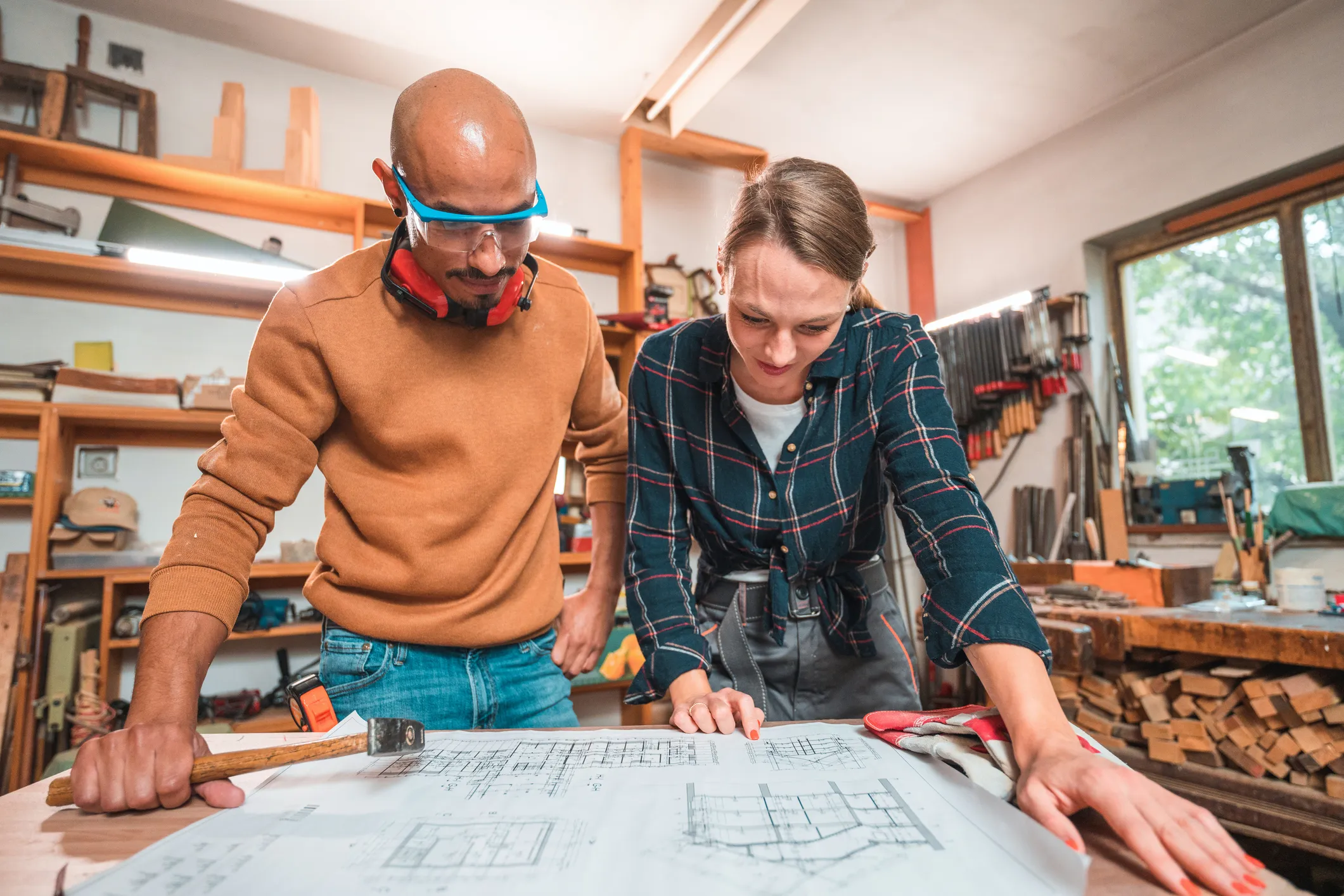 Two building professionals looking at architect plans in a workshop setting