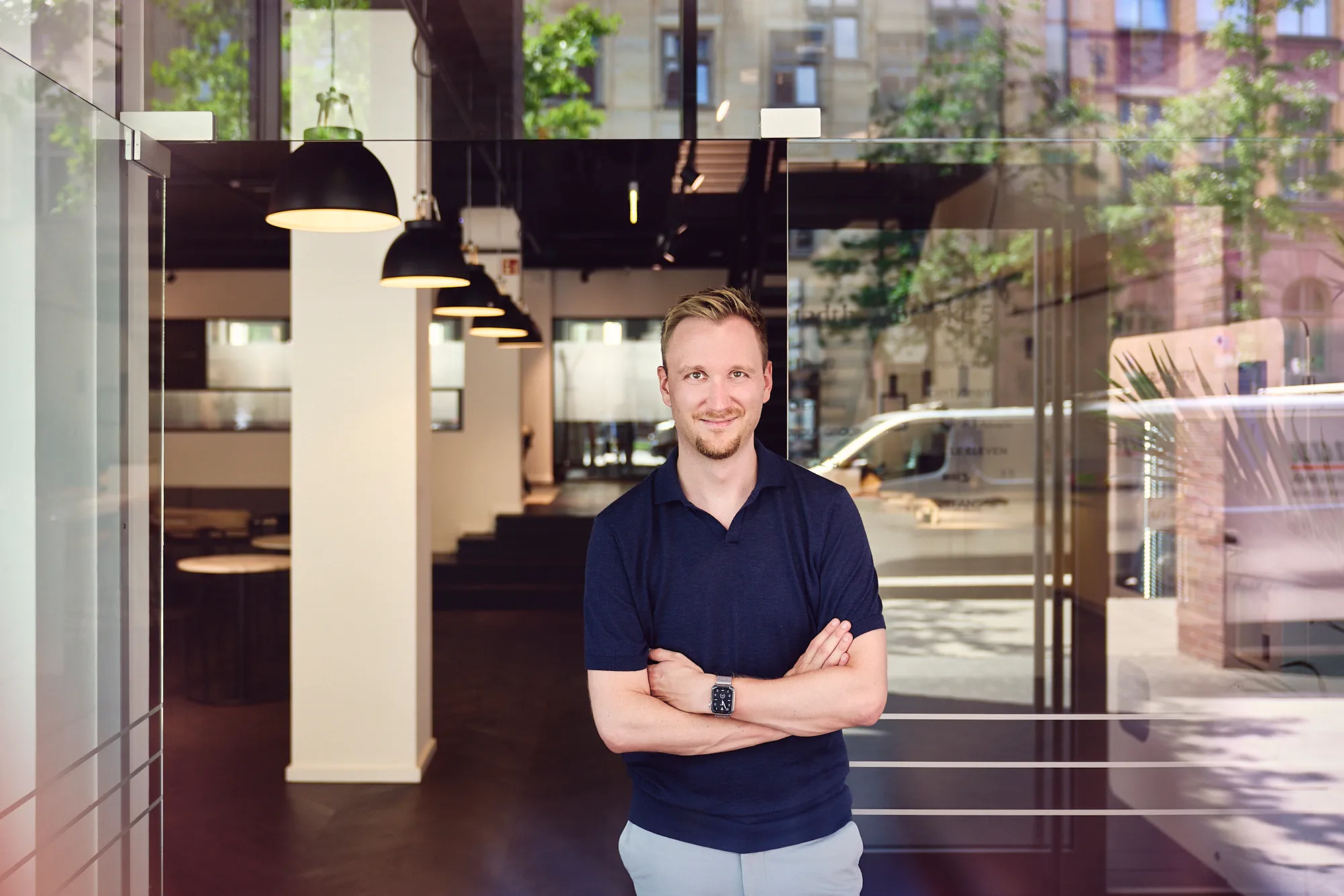 Modernes Büro mit weißen Wänden, schwarzen Bürostühlen, Computermonitoren, Pflanzen und Dekoration.