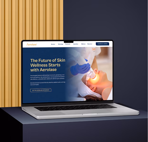 Laptop on a dark pedestal showing a webpage with the headline 'The Future of Skin Wellness Starts with Aerolase' alongside an image of a person receiving a facial laser treatment by a professional wearing blue gloves.
