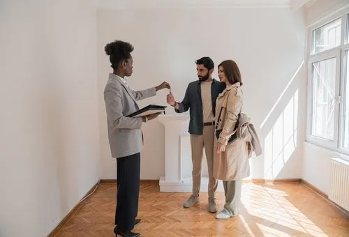 Un agent immobilier remettant les clés d'un appartement à un couple.