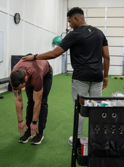  Patient working with a provider at a performance physical therapy clinic in Louisville, KY during a functional movement assessment