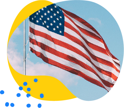 American flag waving against a blue sky with light clouds.