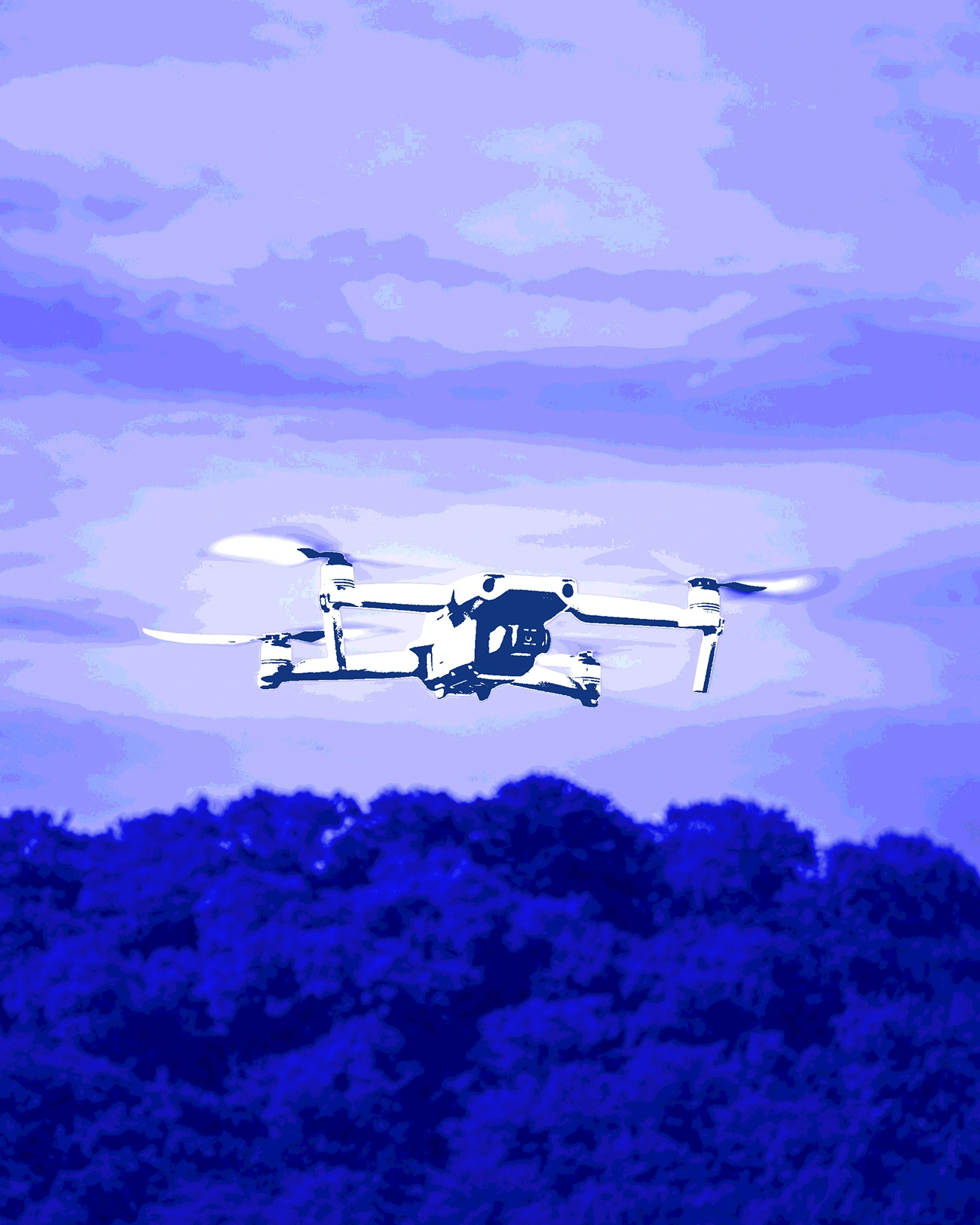 Drone flying above forest for wildfire monitoring.