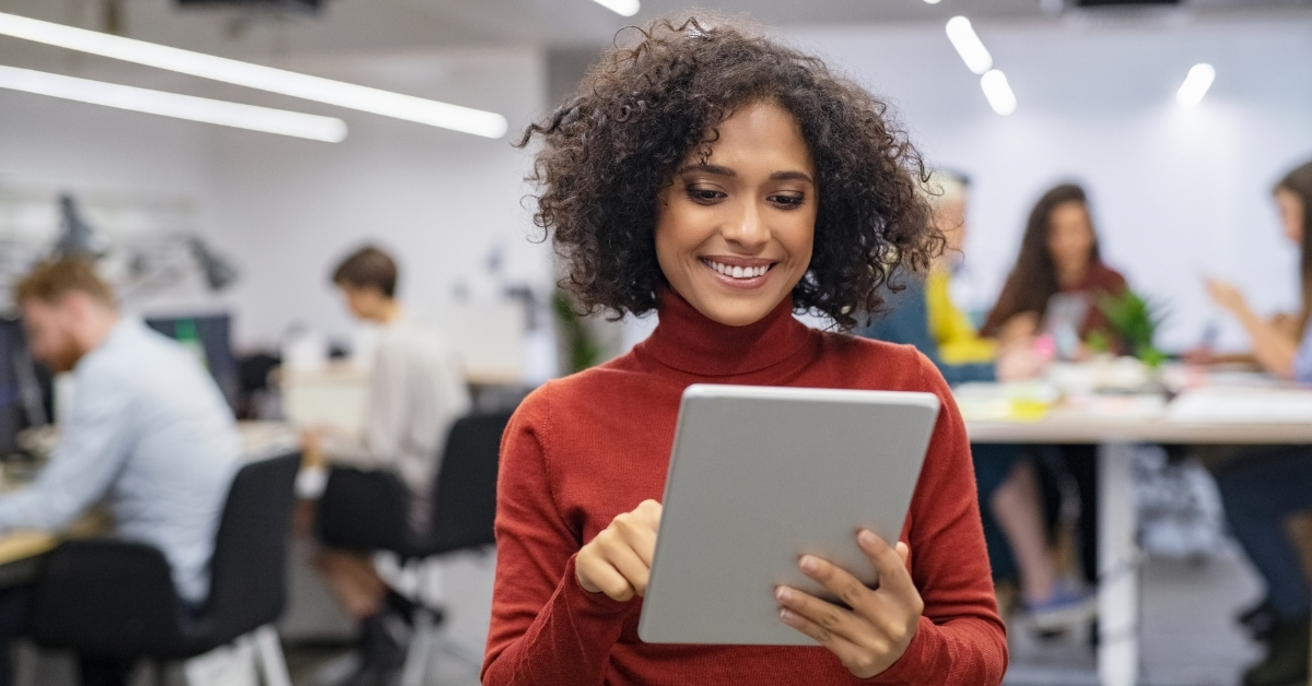 Happy coworking space operator using office automation software to easily manage her workspace.
