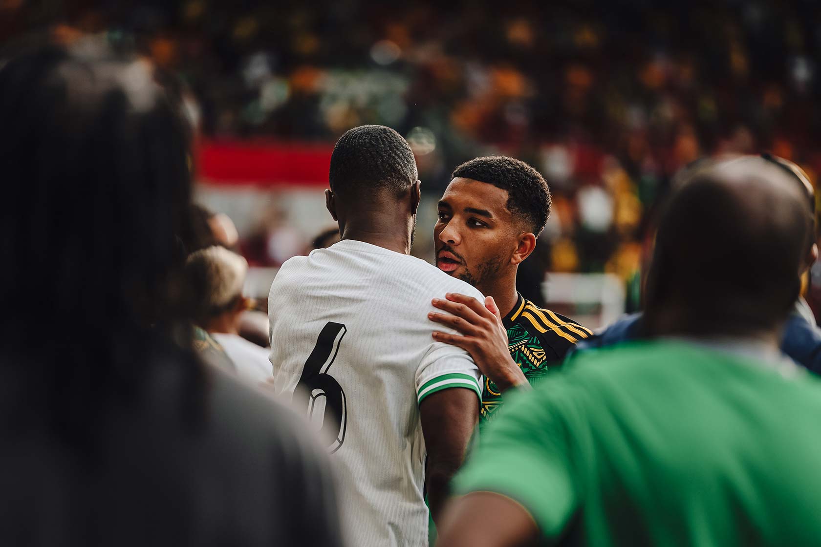 Two football players embracing on the field after the final of the Unity Cup in London.