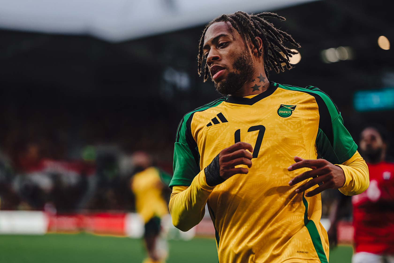Jamaican football player wearing yellow and green jersey during a match.