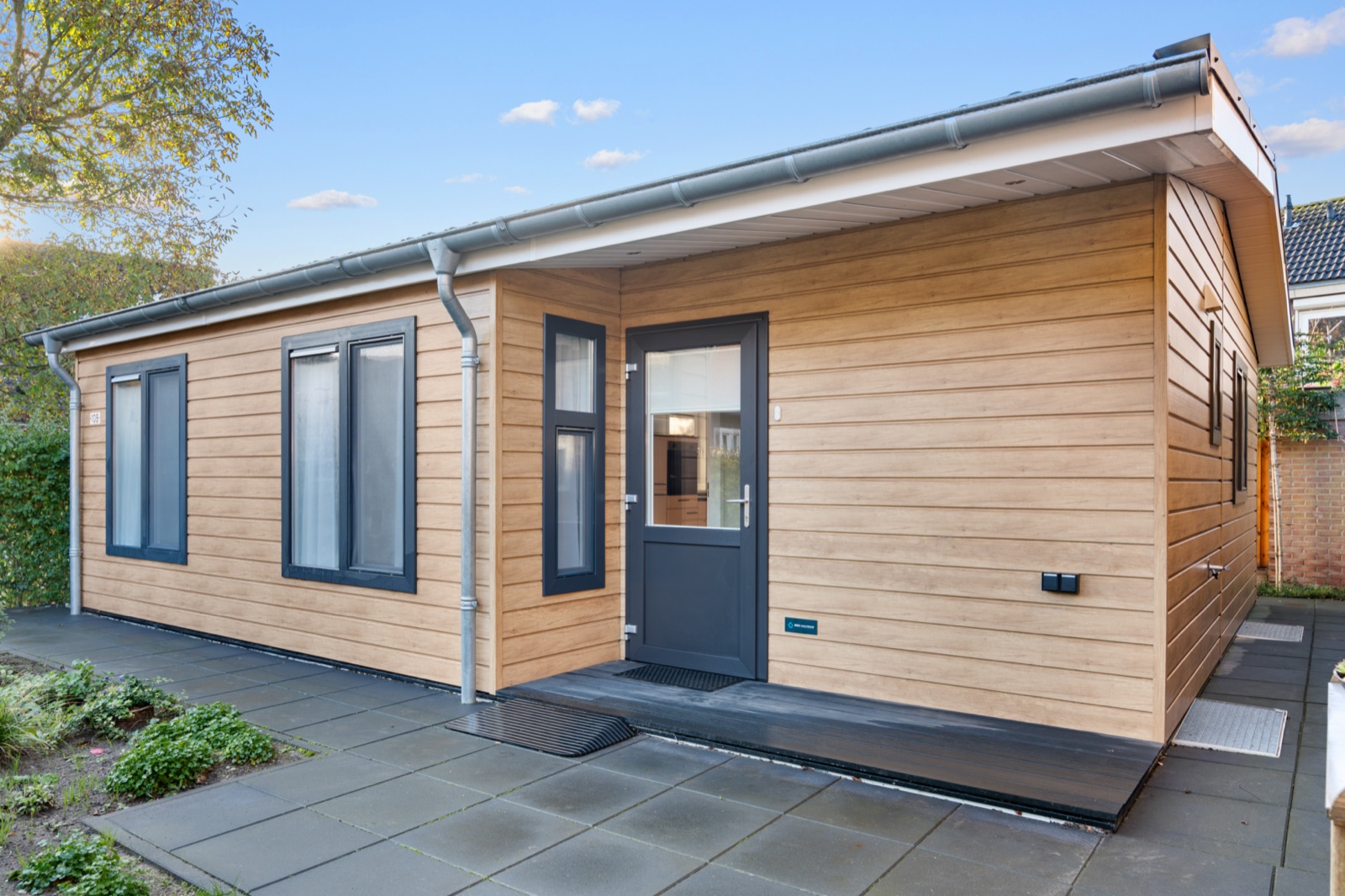 Gelijkvloerse mantelzorgwoning in Randwijk met houten gevelbekleding en antraciet kozijnen