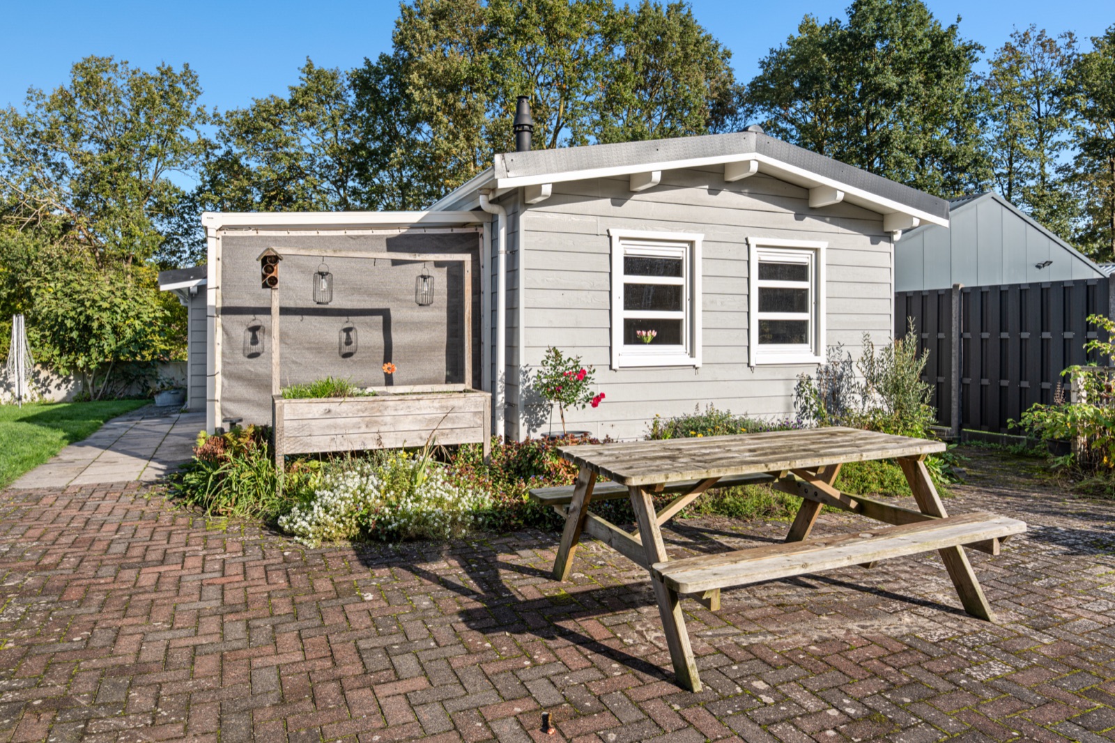 Lichtgrijze houten mantelzorgwoning in Balkbrug met terras en picknicktafel