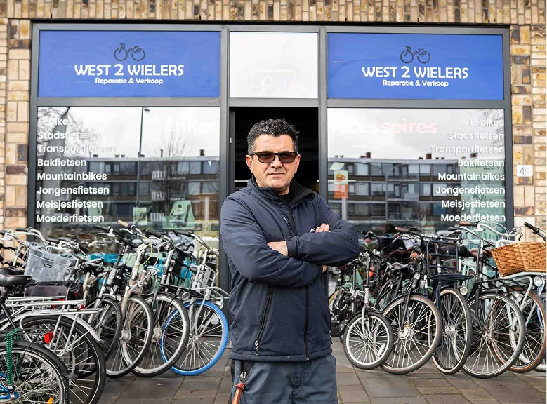 Portret fietsenmaker West 2 Wielers, fietsenwinkel in Vlaardingen. Buiten de winkel.