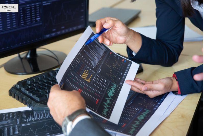 People analyzing trading charts of firms that allow EAs.