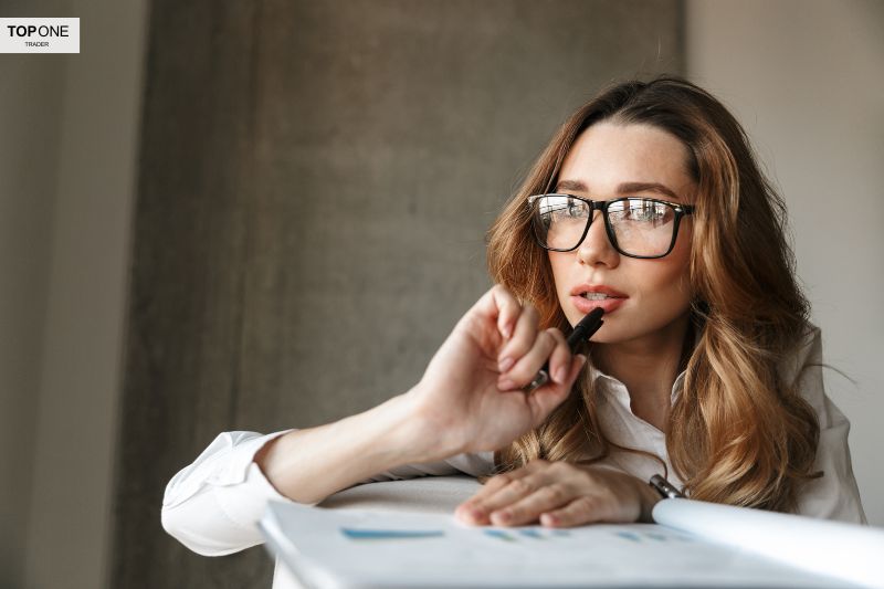 A thoughtful beginner analyzing compound trading strategies, holding a pen and reviewing notes to enhance financial understanding.