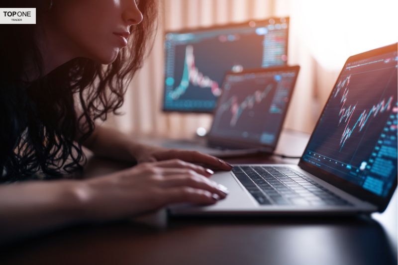 A focused trader analyzing fluctuating forex charts on multiple screens, assessing market trends and risk management strategies.