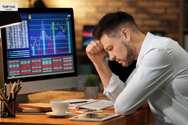 A stressed trader questions losses at his desk—wondering, is prop trading worth it?