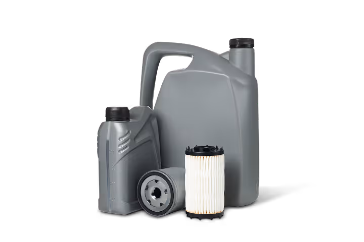 Two gray motor oil containers and two cylindrical oil filters on black background.