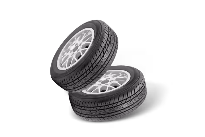 Two black car tires with silver alloy rims stacked against a transparent background.