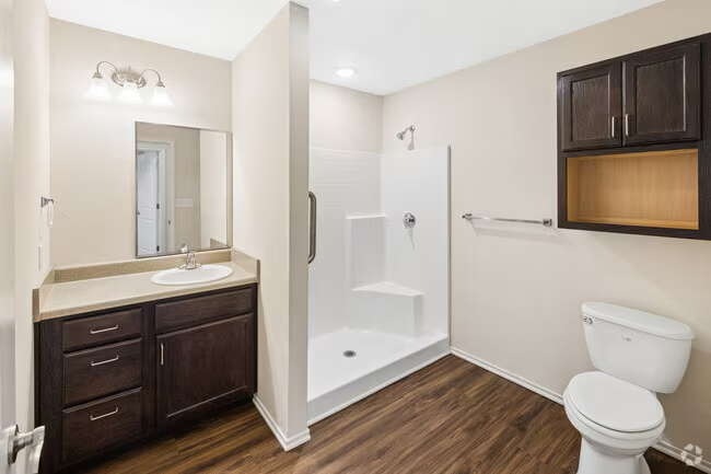 Bathroom with walk in shower and brown cabinets