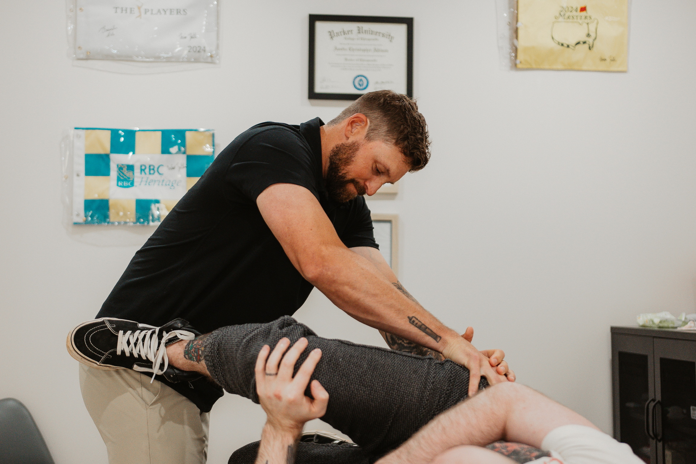 Therapist performing a leg stretch on a client lying down in a therapy room.