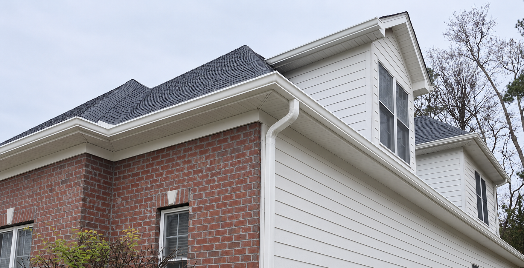 Close-up of roof with lifted and missing shingles exposing the underlayment beneath