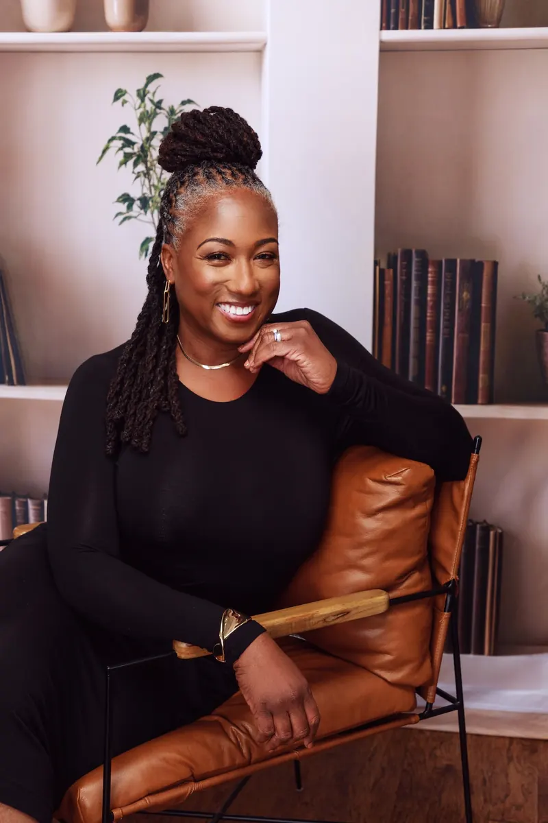 Dianne Adkins-Forte smiling, seated in a leather chair
