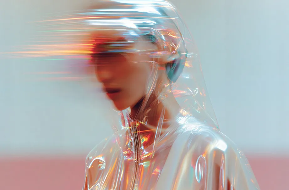 Person wearing a transparent, reflective hooded jacket with blurred face and horizontal light streaks.