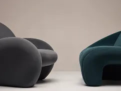 Modern round chairs in dark gray and teal colors on a light floor with a neutral background.