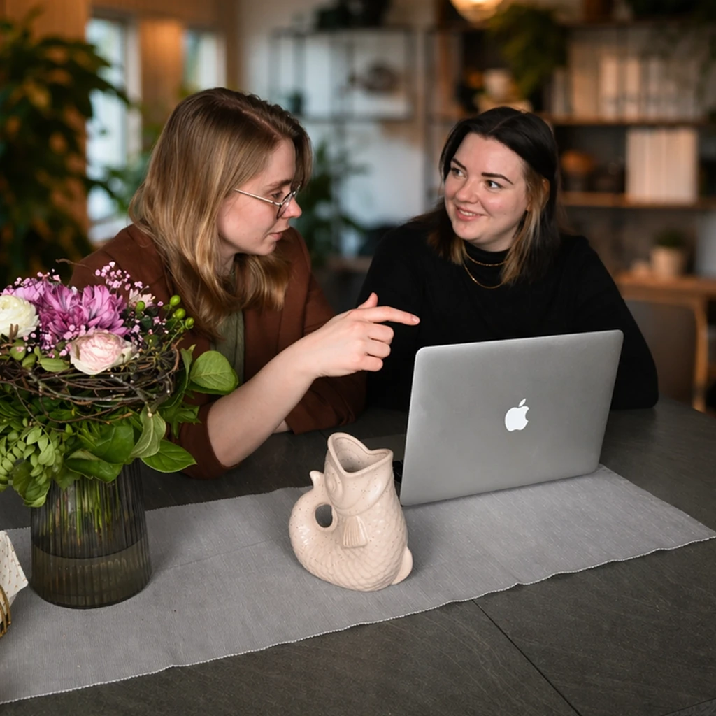 Elisabeth und Lena sitzen an einem Tisch und tauschen sich angeregt aus.
