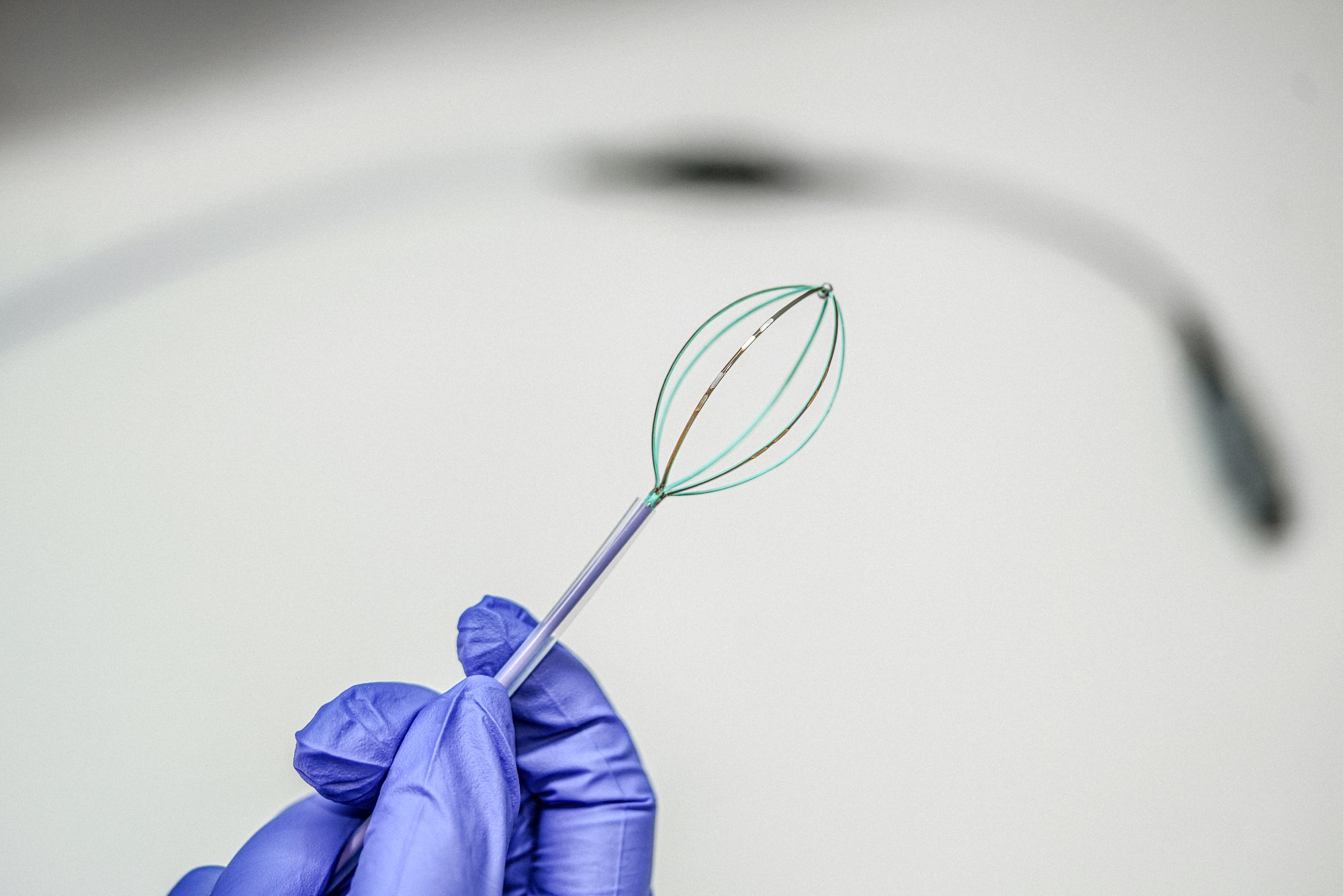 Gloved hand holding a basket catheter prototype