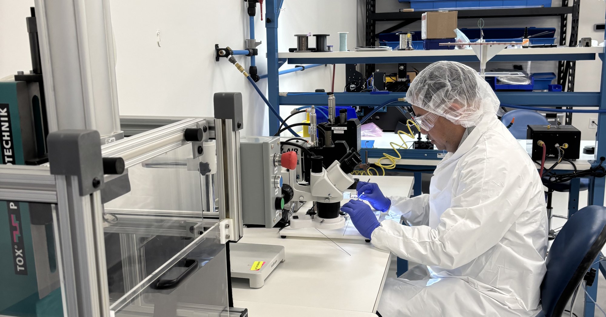 Technician performing device testing at an equipment bench