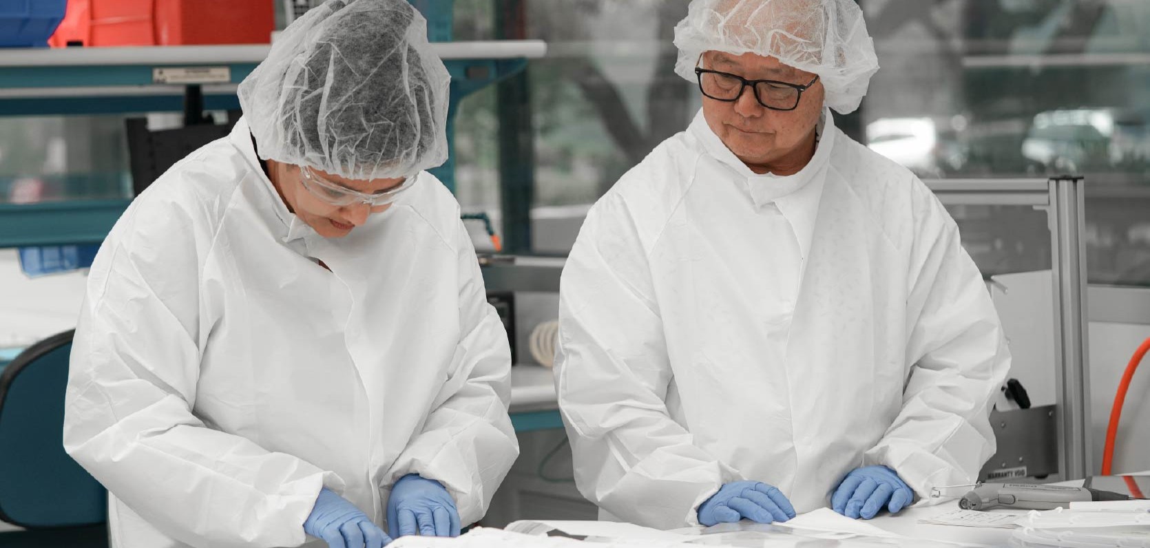 Engineers reviewing formed components at a process development bench
