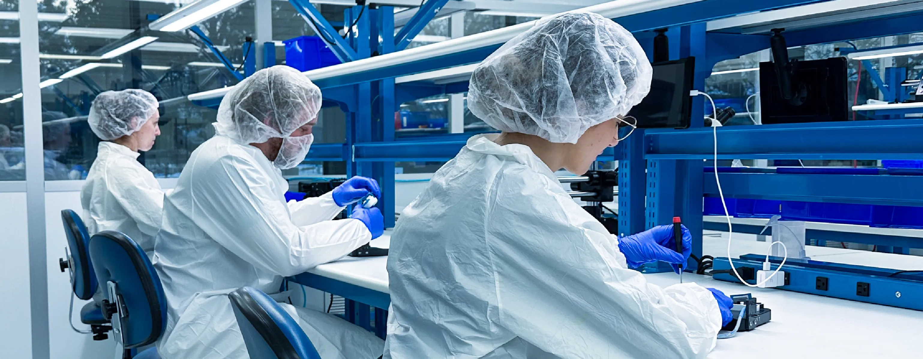 Cleanroom technicians documenting work at production benches