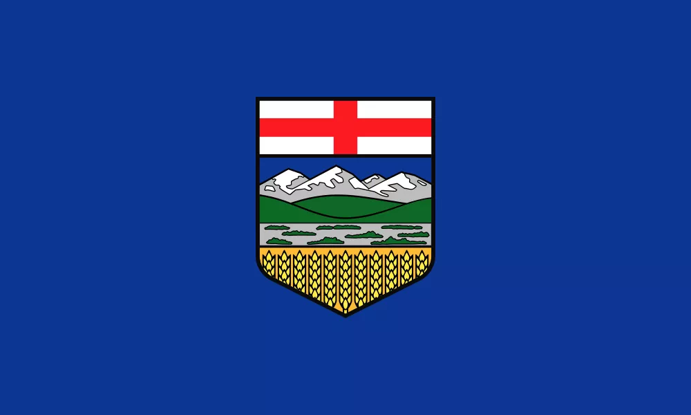 Flag of Alberta with a blue background, a shield featuring the red cross of St. George above snow-capped mountains, green foothills, a river, and a golden wheat field.