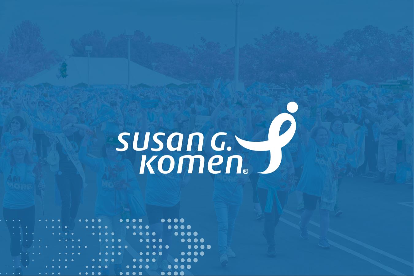 Crowd of people walking outdoors at a charity event with Susan G. Komen logo overlay.