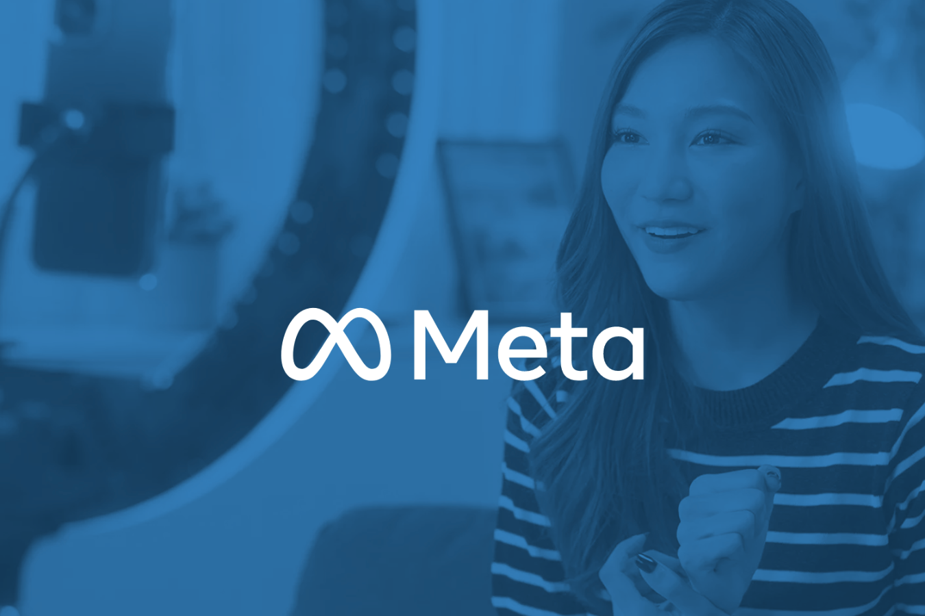 Smiling woman sitting indoors with the Meta logo overlayed on the image.
