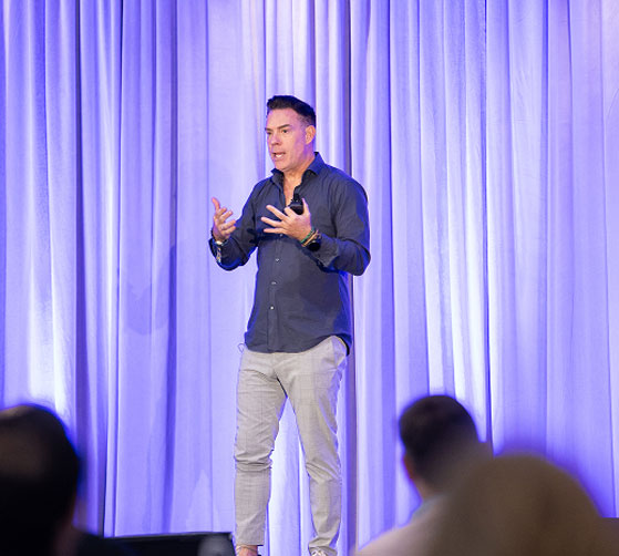 Paul speaking on stage at a convention