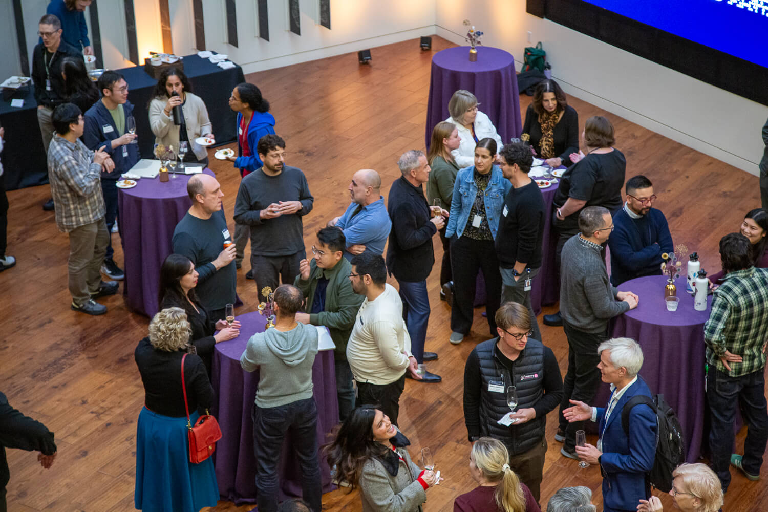 Aerial view of people networking at conference with purple tablecloths and wooden floor