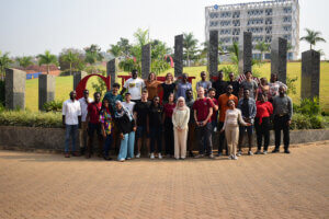 Large group of people standing together in front of colorful modern sign